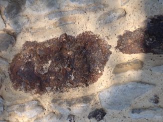 Puddingstone in south wall of St James The Less | NT